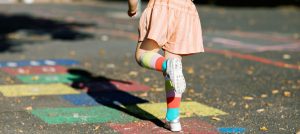 young child playing hopscotch