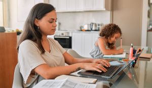 Parent writing out nursery application for younger child